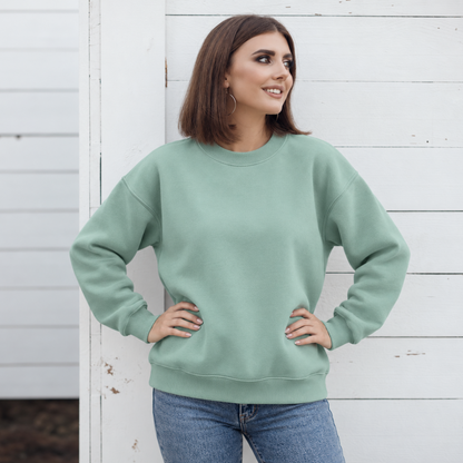 Dusty Sage crewneck color mockup shown on a model; embroidery added through personalization